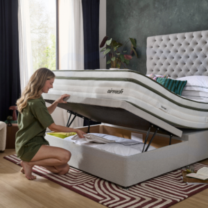 Image of a woman opening the lid of a half-opening ottoman with a Silentnight Airmesh mattress on top